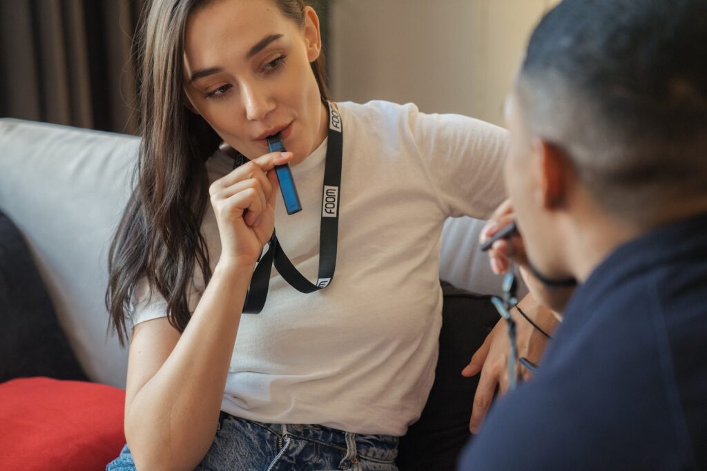 a woman sitting on a couch holding a toothbrush in her mouth